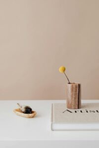 Incense and a coffee table book on a white table